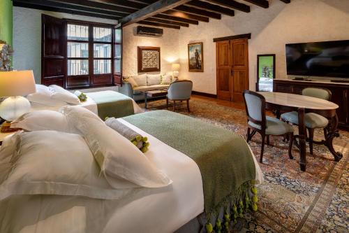 a hotel room with two beds and a table at Las Cruces Boutique Hotel in Antigua Guatemala