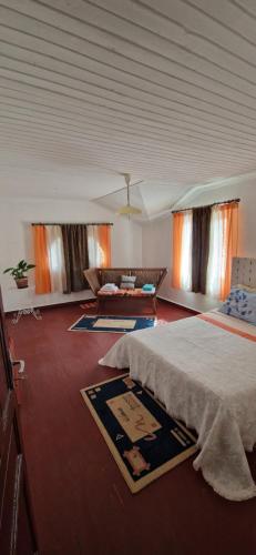 a large room with a bed and a couch at Villa Margarit Ravel in Talata-maty