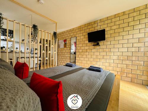 a bedroom with a bed and a tv on a brick wall at Family M Apartments 1 in Kappel bei Olten