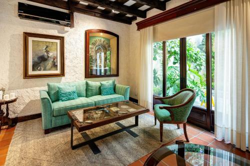 a living room with a green couch and a table at Las Cruces Boutique Hotel in Antigua Guatemala
