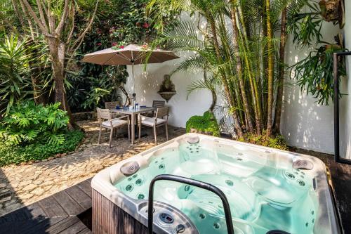 a jacuzzi tub in a garden with a table at Las Cruces Boutique Hotel in Antigua Guatemala
