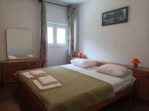 a bedroom with a bed with two towels on it at Garden Apartment Braut in Kornić