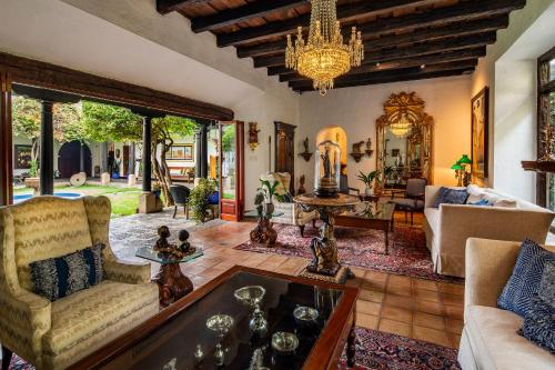 a living room with a couch and a chandelier at Las Cruces Boutique Hotel in Antigua Guatemala