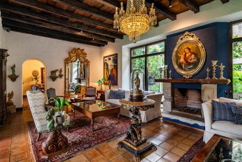 a living room with a fireplace and a chandelier at Las Cruces Boutique Hotel in Antigua Guatemala