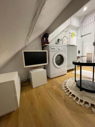 Il comprend un salon avec une télévision et un lave-linge. dans l'établissement Super logement à Paris !, à Paris