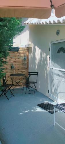 a patio with two chairs and a table next to a door at Cosy Garden Studio in Messini