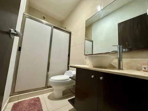 une salle de bain avec un lavabo, des toilettes et un miroir dans l'établissement Casa en el corazón de Playa del Carmen, à Playa del Carmen