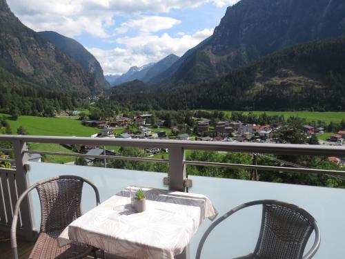 a table and chairs on a balcony with mountains at Haus Stefan in Oetz