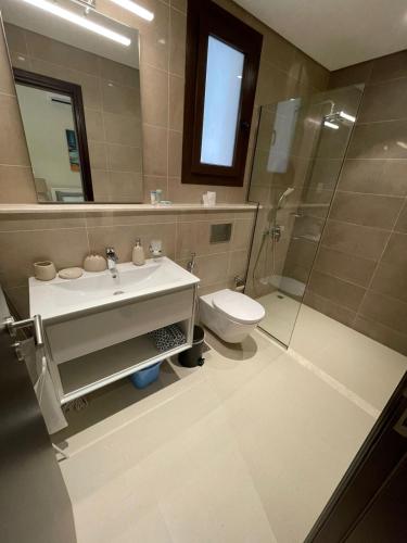 a bathroom with a sink and a toilet and a shower at Darcy's Studio in Salalah