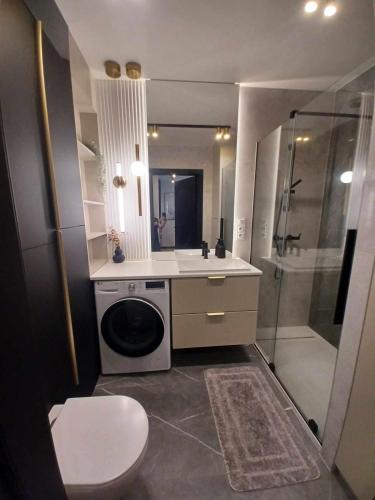 a bathroom with a shower and a washing machine at Jantar Up in Jantar