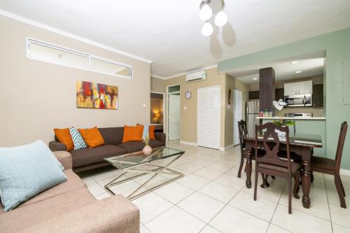 a living room with a couch and a table at Choose To Be Happy at Brompton Estates - One and Two Bedroom with Pool in Kingston