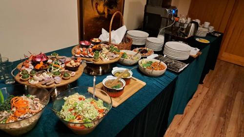 a table with a bunch of different types of food at Pałac Spichrz in Borcz