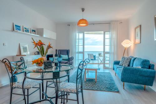 a living room with a table and a blue couch at Casa Serena Apartments in Arco da Calheta