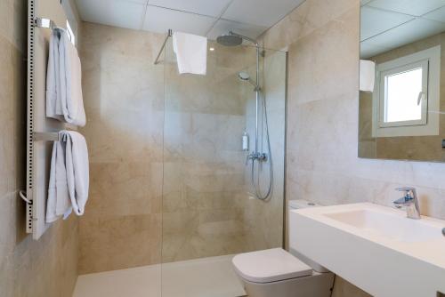 a bathroom with a shower and a toilet and a sink at Hotel Hostalillo by Escampa Hotels in Tamariu