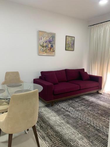 a living room with a red couch and a glass table at Lime-apart in Tivat