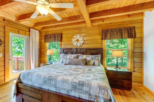 a bedroom with a bed with wooden walls and windows at Owls Nest Pet-Friendly Cabin with Private Hot Tub in Ranger