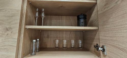 a wooden cupboard with glasses in it at AppPrusnik in Ljubljana