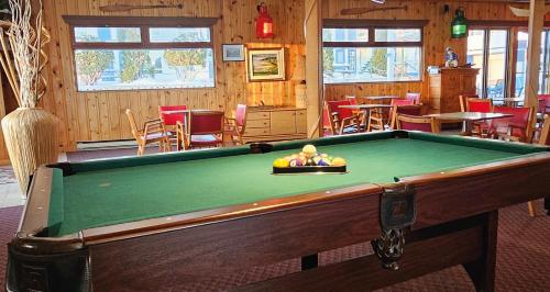 a pool table in the middle of a room at Hotel-Motel Les Voitures d'Eau in L'Isle-aux-Coudres