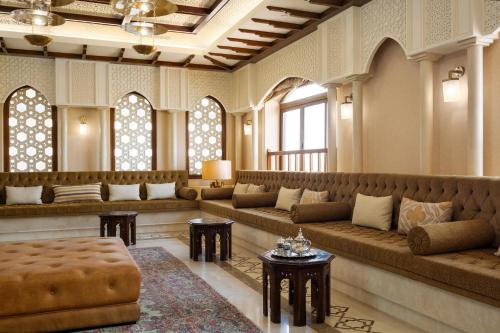 a living room with couches and tables and windows at InterContinental Durrat Al Riyadh Resort & Spa by IHG in Riyadh