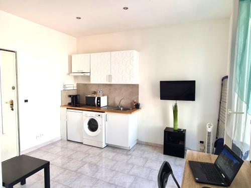une cuisine avec un lave-linge et un micro-ondes dans l'établissement NICE - Studio cosy hypercentre à 500m de la plage, à Nice