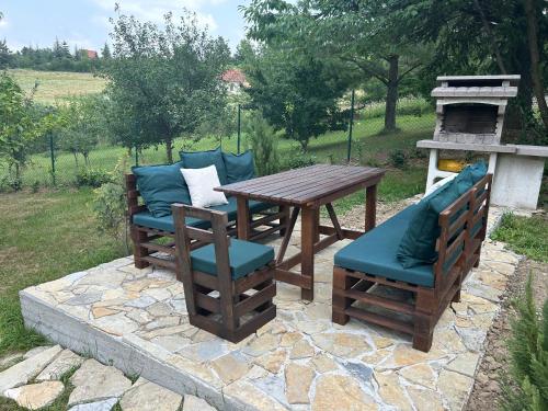 a wooden table and chairs on a stone patio at Kosmaj Ruža vetrova in Sopot