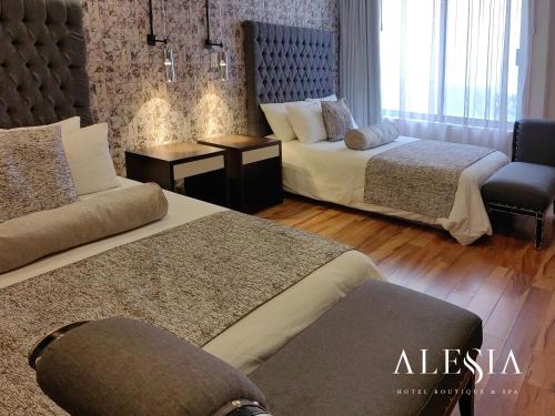 a hotel room with two beds and a chair at Alesia - Boutique Hotel & Spa in Aguascalientes