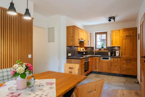 a kitchen with wooden cabinets and a wooden table at Gutzingerhof in Bad Kleinkirchheim