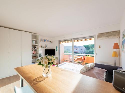 un salon avec une table avec un vase de fleurs dessus dans l'établissement Apartment Résidence du Parc by Interhome, à Cavalaire-sur-Mer