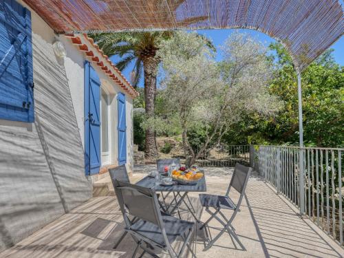 un patio avec une table, des chaises et un palmier dans l'établissement Holiday Home La Source by Interhome, à La Cadière-dʼAzur