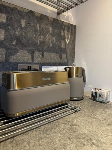a kitchen with a counter top with a goldounter at Deluxe Inn Gateshead in Gateshead
