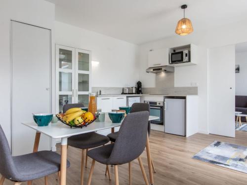 une cuisine avec une table avec un bol de fruits dessus dans l'établissement Apartment Cap Océan-12 by Interhome, à Capbreton