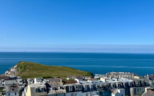 a city with houses and the ocean in the background at The Lookout in Ilfracombe