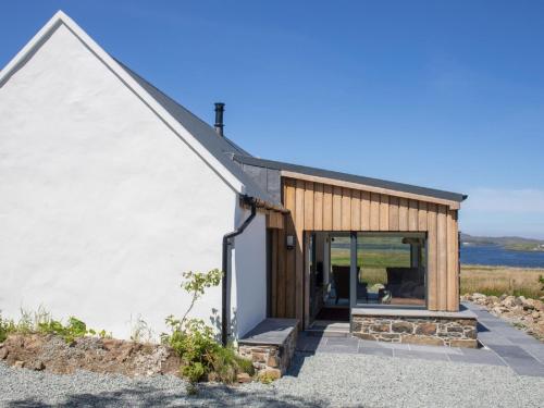 a house with a glass door on the side of it at Holiday Home Finnan's Byre by Interhome in Eyre