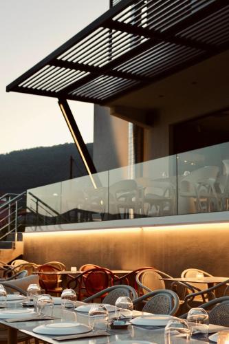 a row of tables and chairs with glasses on them at AKROTHEA suites & lounge in Tripolis