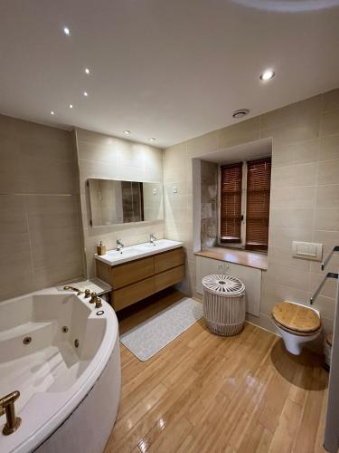 une salle de bain avec une baignoire, un lavabo et des toilettes dans l'établissement Maison avec plan d'eau, à Saint-Gervais-du-Perron