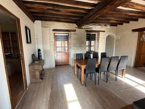 una sala da pranzo con tavolo e sedie in legno di Maison avec plan d'eau a Saint-Gervais-du-Perron