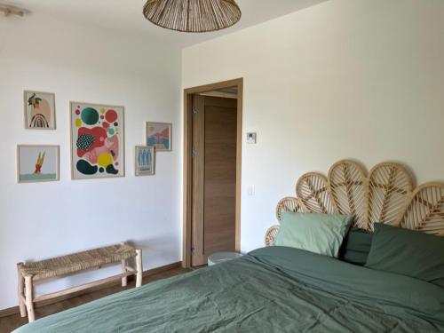 a bedroom with a green bed with a wooden headboard at La Villa di Paraso in Ville-di-Paraso