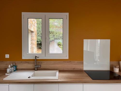 a kitchen with a sink and a window at La Villa di Paraso in Ville-di-Paraso