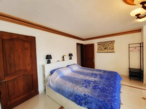 a bedroom with a bed with a blue comforter at Reverie in Willemstad