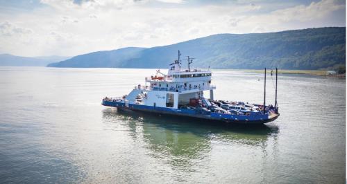 a large ferry boat on a large body of water at Hotel-Motel Les Voitures d'Eau in L'Isle-aux-Coudres