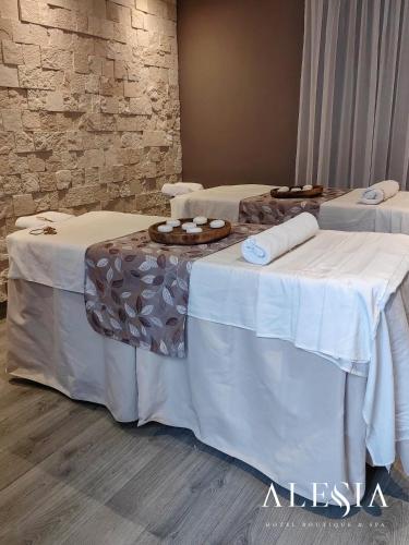 two beds with white tables in a room at Alesia - Boutique Hotel & Spa in Aguascalientes