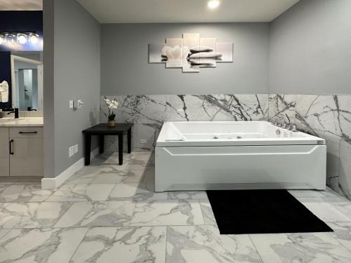 a bathroom with a white tub and a black rug at BayVue Hotel, Resort & Suites in Ocean Shores
