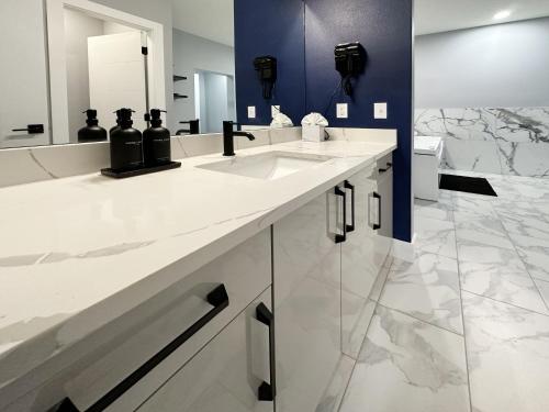 a bathroom with two sinks and a large mirror at BayVue Hotel, Resort & Suites in Ocean Shores