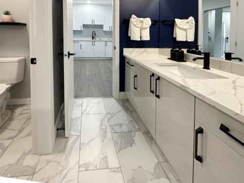 a bathroom with two sinks and a toilet at BayVue Hotel, Resort & Suites in Ocean Shores