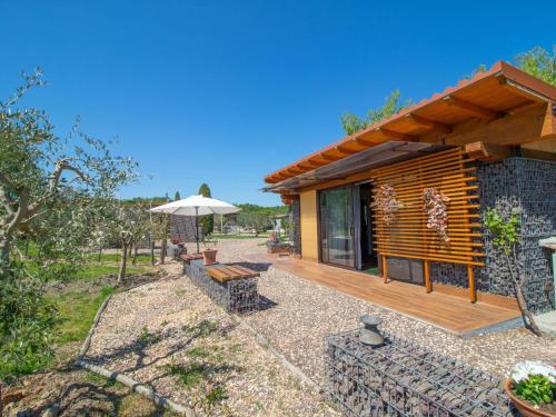a log cabin with a deck and an umbrella at Chalet Il Vitigno by Interhome in Sutri