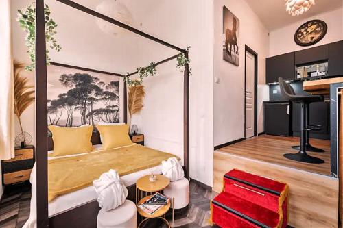 - une chambre avec un lit à baldaquin et un piano dans l'établissement Le Cupidon, En plein Coeur de Lorient, à Lorient