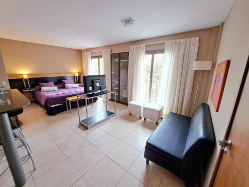 a living room with a bed and a couch and a television at Tierra Mora in San Rafael