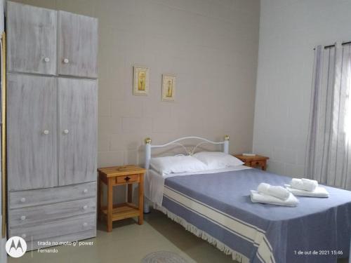 クーニャにあるChale na natureza dentro pousada pedacinho do ceuのベッドルーム1室(ベッド1台付)、ドレッサー(タオル付)