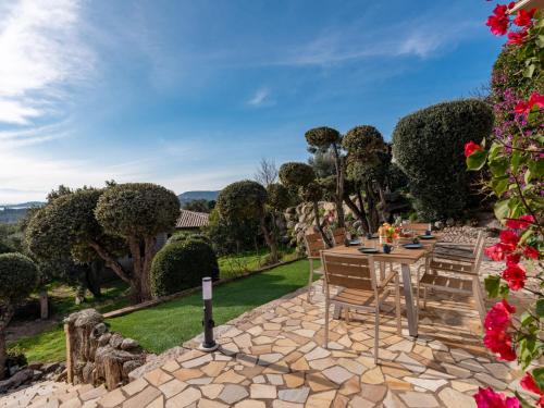 - une terrasse avec une table, des chaises et des fleurs dans l'établissement Holiday Home Villa Sognu by Interhome, à Sainte-Lucie de Porto-Vecchio