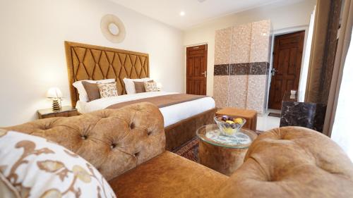 a hotel room with a bed and two couches at Walisons Homestay Abelia in Srinagar